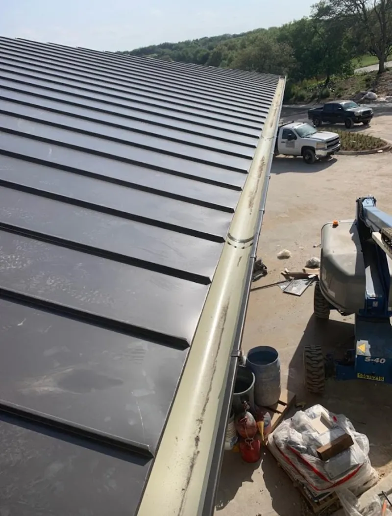 Standing seam panel and gutter detail on a metal roofing jobsite in Ellicott
